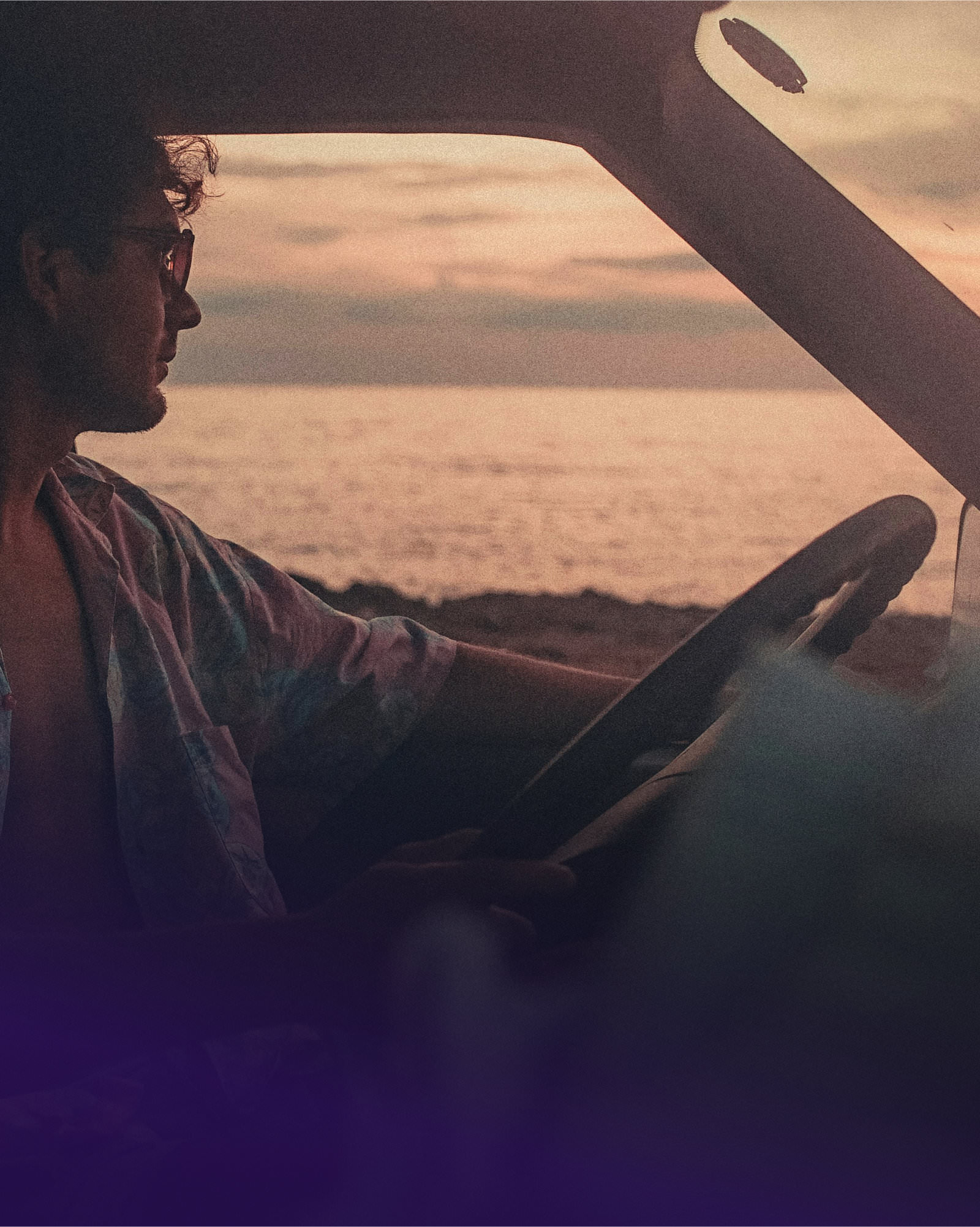 Foto von einem Mann, der aus seinem Fahrzeug auf das Meer schaut